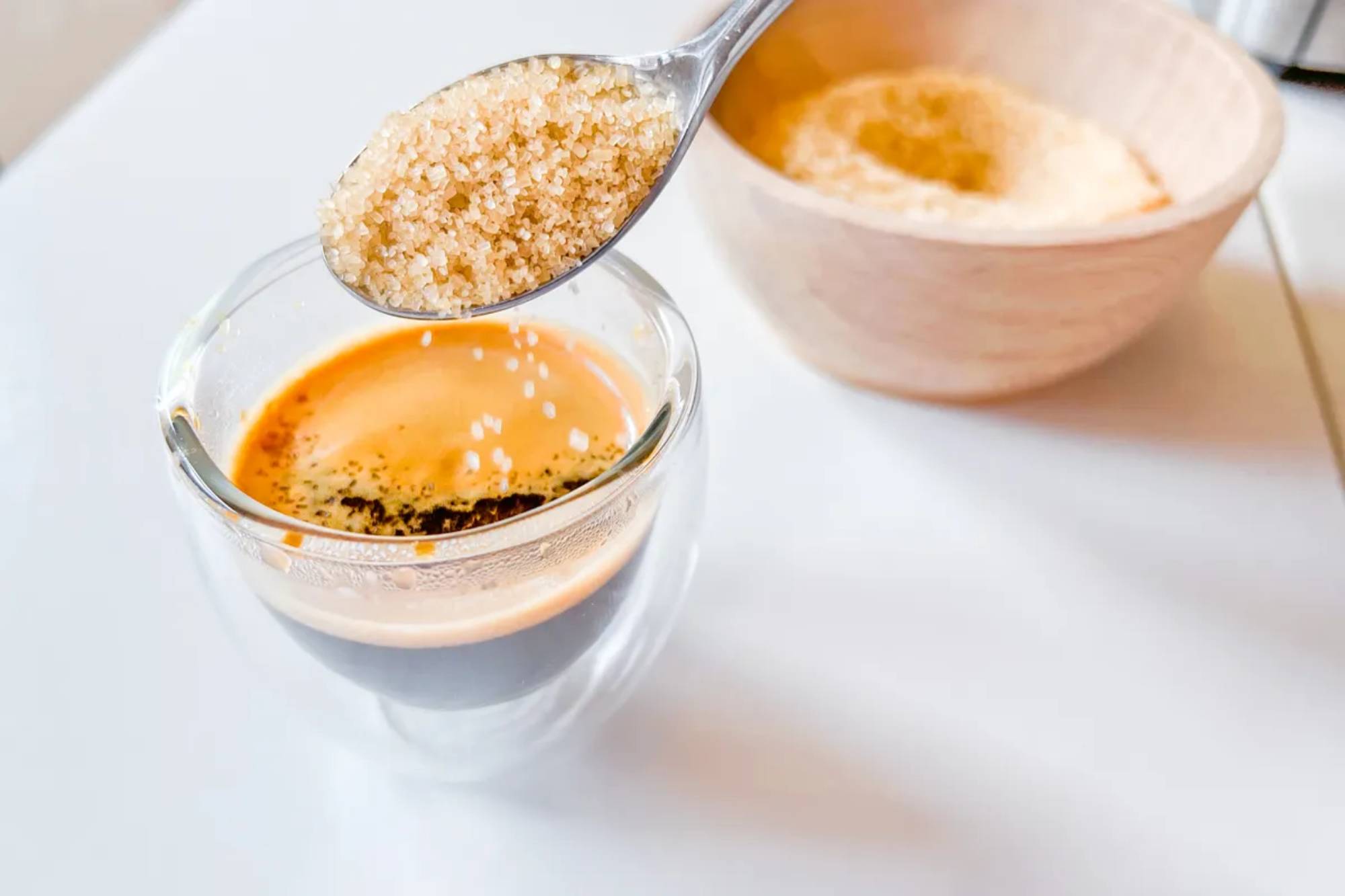 Sukker tilsættes en espresso i et glas