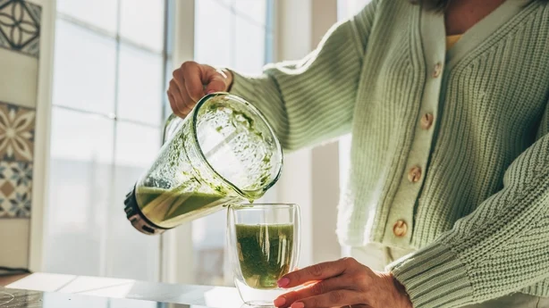 Ung kvinde laver detox-smoothie