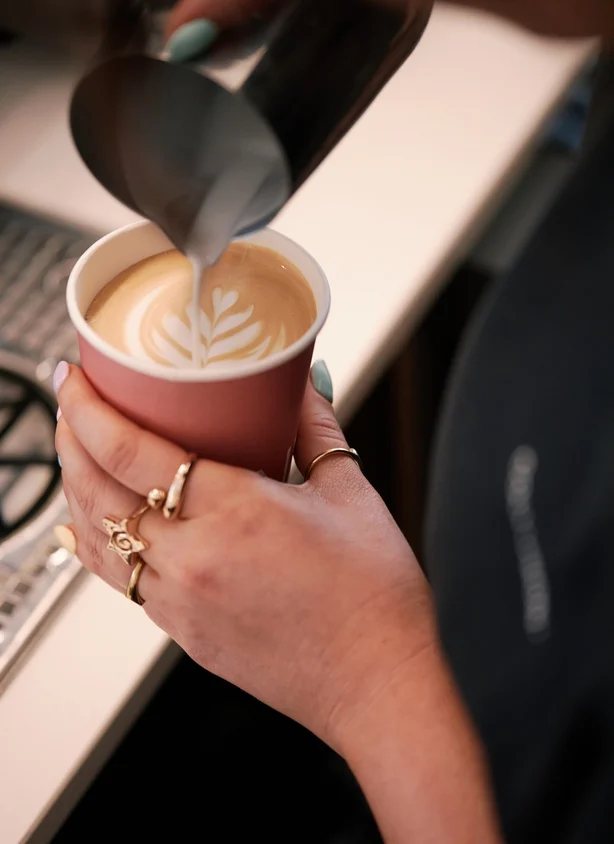 En barista laver en kop kaffe