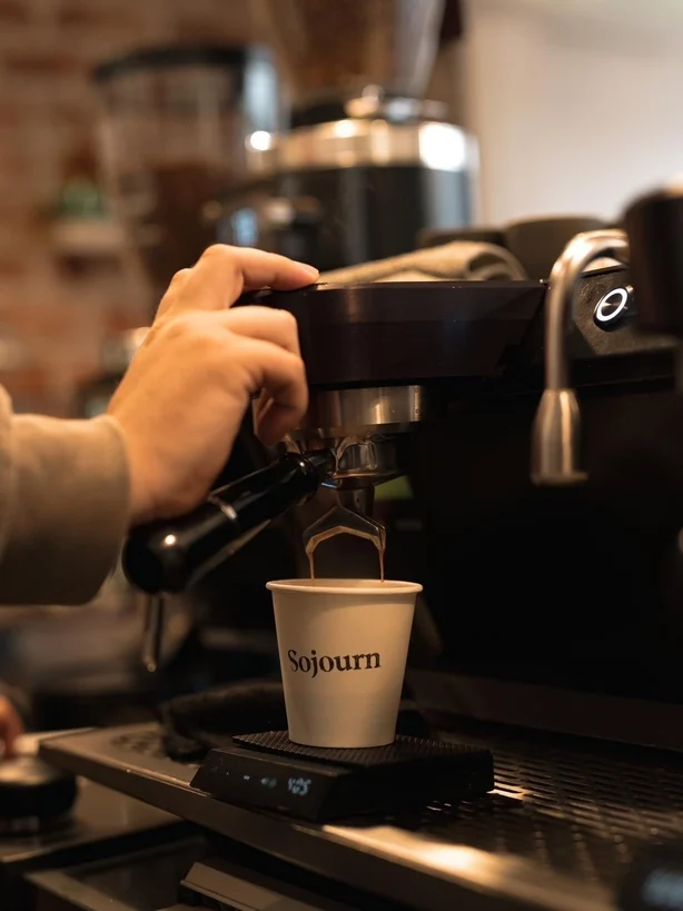 En barista trækker et skud espresso ved en kaffemaskine